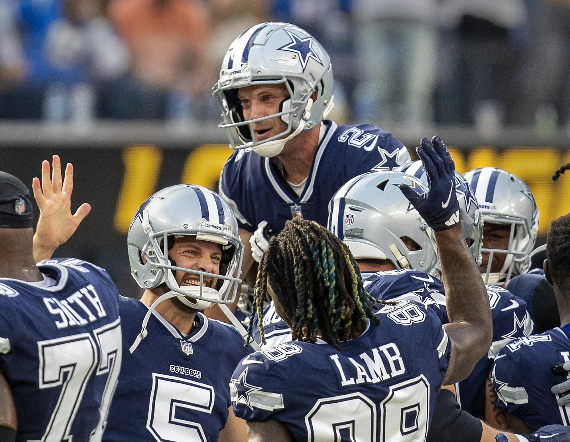 The Dallas Cowboys celebrate and hoist kicker Greg Zuerlein off the field after his 56-yard field goal.