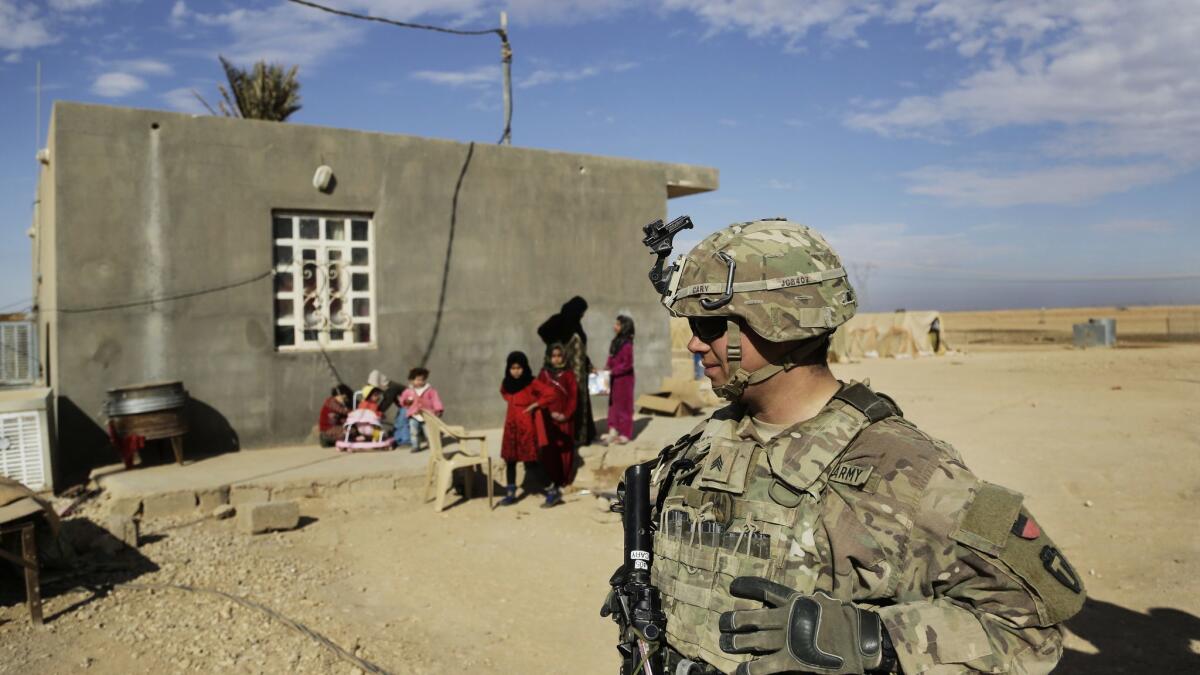 In this Jan. 27 photo, U.S. Army soldiers in Iraq speak to families in rural Anbar during a reconnaissance patrol.