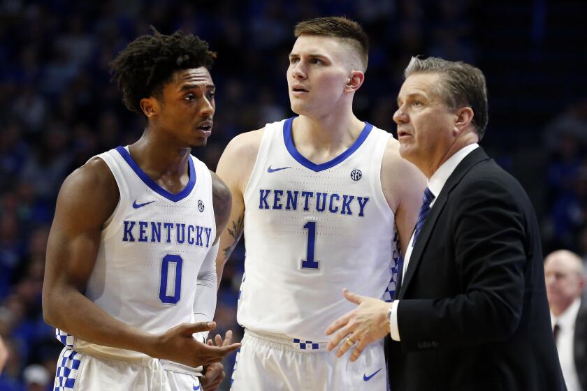 Kentucky's Ashton Hagans (0) and Nate Sestina (1) talk with coach John Calipari during the second half of the team's NCAA college basketball game against Mississippi State in Lexington, Ky., Tuesday, Feb. 4, 2020. Kentucky won 80-72. (AP Photo/James Crisp)