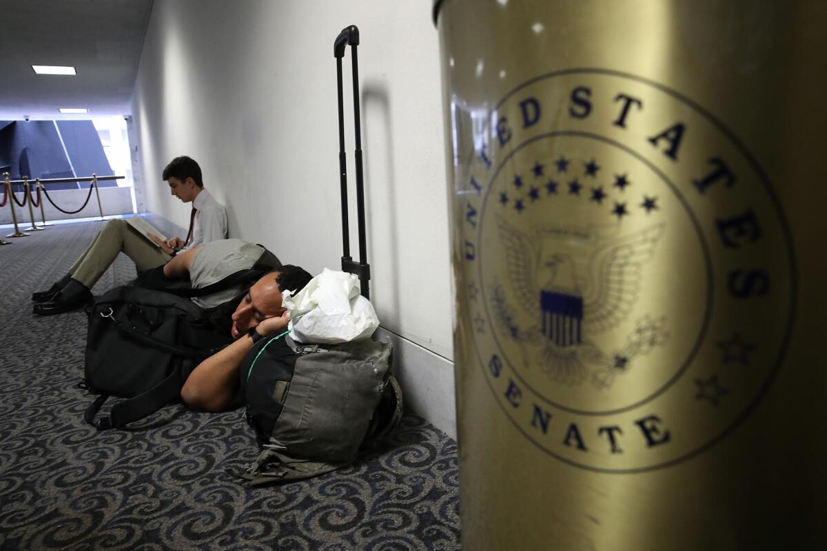 A member of the public sleeps in line while waiting for the room to open for Atty. Gen. Jeff Sessions' testimony before the Senate Intelligence Committee.