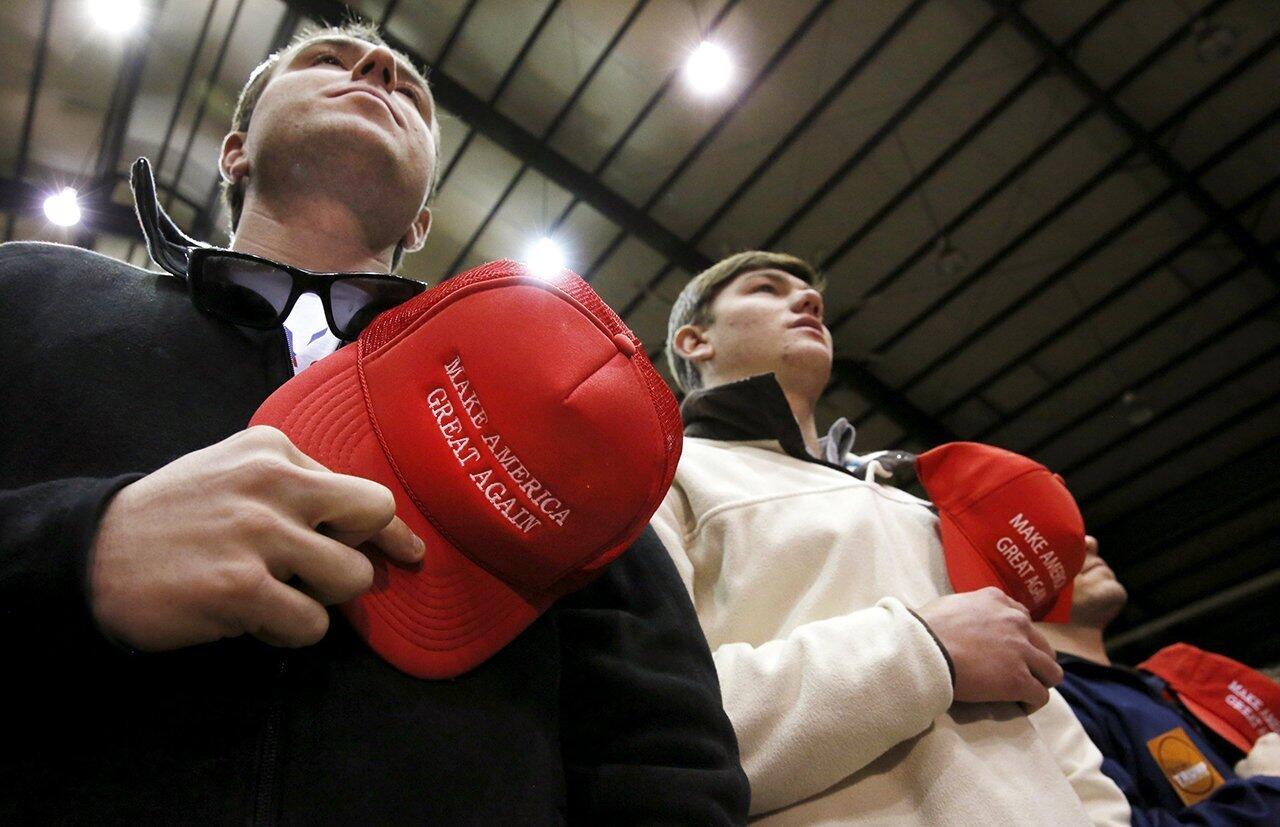 Supporters of Republican U.S. presidential candidate Donald Trump stand with their "Make America Great Again" caps doffed during the Pledge of Allegiance before a rally with Trump at Clemson University.