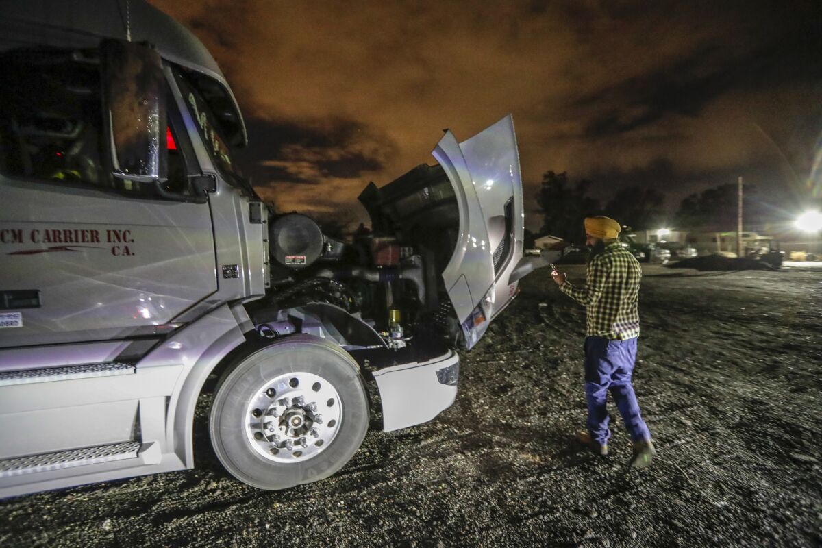 Singh checks his truck before getting on the road for a week-long trip to Indiana to deliver fresh produce from California. (Irfan Khan / Los Angeles Times)