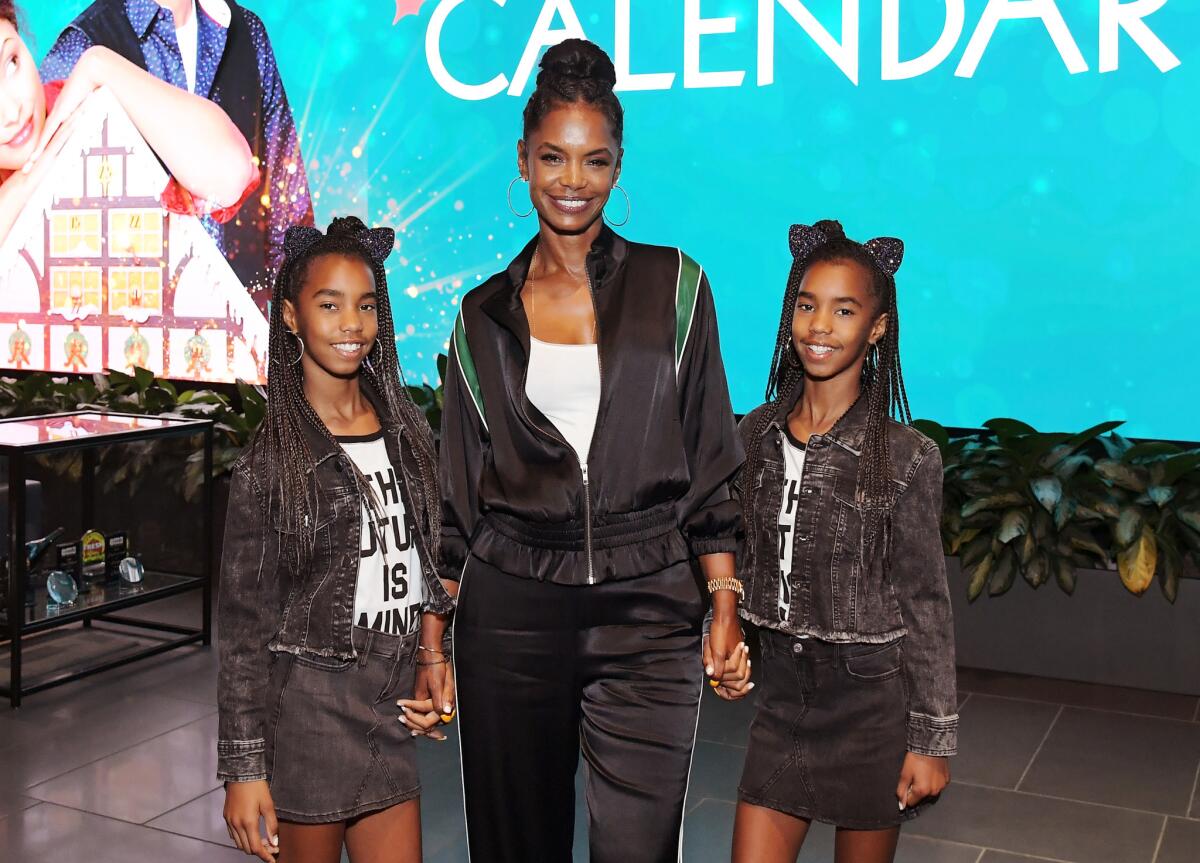 Kim Porter, center, and her twin daughters at "The Holiday Calendar" screening in Los Angeles on Oct. 30, 2018.