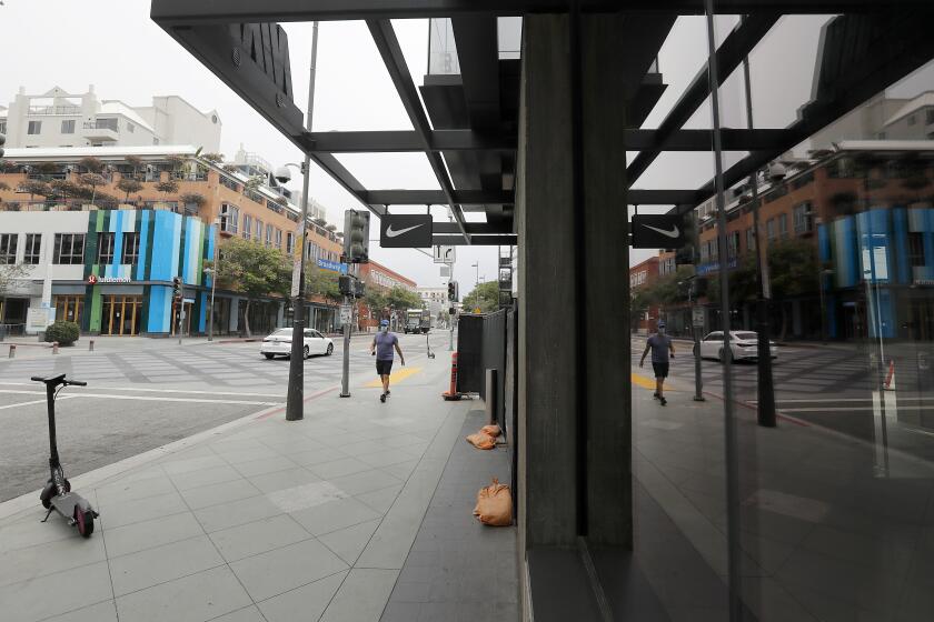 SANTA MONICA, CALIF. - MAY 8, 2020. Santa Monica Place and the Third Street Promenade in Santa Monica are largely deserted on Friday, May 8. 2020. As coronavirus restrictions are loosened, retail shops are allowed to reopen if they provide curbside pickup and practice social distancing. However, most shops in downtown Santa Monica remained closed on Friday. (Luis Sinco/Los Angeles Times)