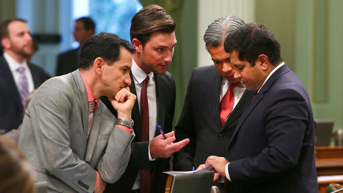 Democratic Assembly members, from left, Anthony Rendon, Ian Calderon, Rob Bonta and Jimmy Gomez huddle during the 2015 session. (Rich Pedroncelli / Associated Press)