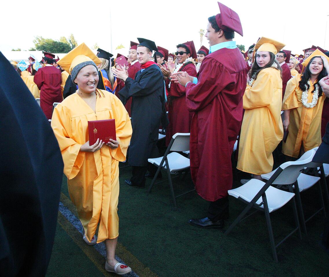 The last graduate, Melissa Leo, strides through her class of applauding graduates at the graduation of La Canada High School on the football field in La Canada Flintridge on Thursday, June 5, 2014. Leo is battling an aggressive form of leukemia which nearly took her life over the semester.