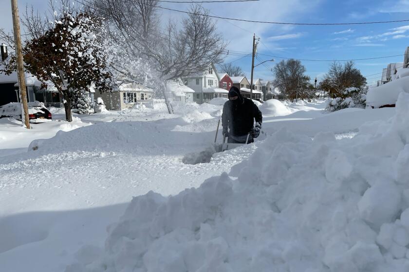 Martin Haslinger uses a snowblower outside his home in Buffalo, N.Y., on Saturday, Nov. 19, 2022 following a lake-effect snowstorm. Residents of northern New York state are digging out from a dangerous lake-effect snowstorm that had dropped nearly 6 feet of snow in some areas and caused three deaths. The Buffalo metro area was hit hard, with some areas south of the city receiving more than 5 feet by early Saturday. (Bridget Haslinger via AP)