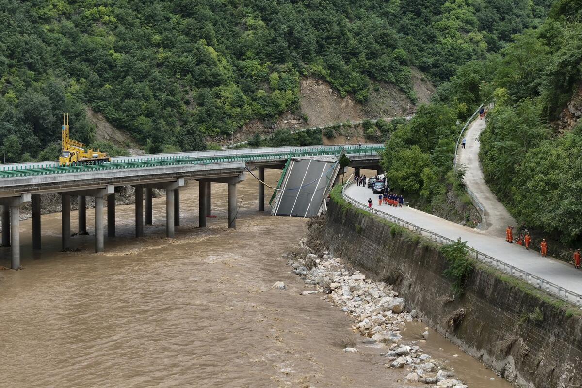 Water flows under a collapsed bridge.