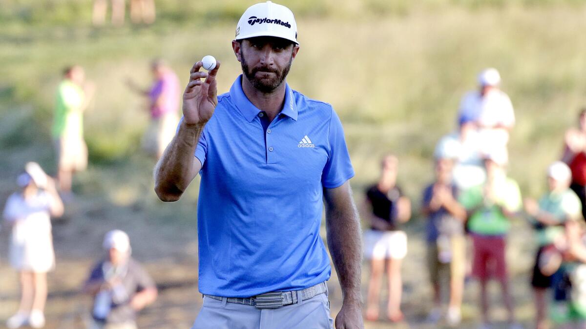 Dustin Johnson acknowledges the cheers after making a birdie on the sixth hole during the rain-delayed second round of the U.S. Open on Friday.