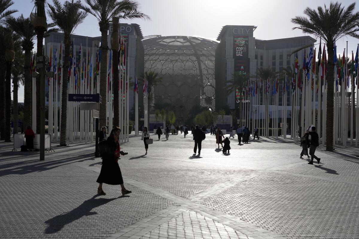 People walk through the venue at the COP28 U.N. Climate Summit in Dubai, United Arab Emirates.