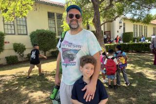 A man stands with his 7-year-old son outside of Aldama Elementary School.