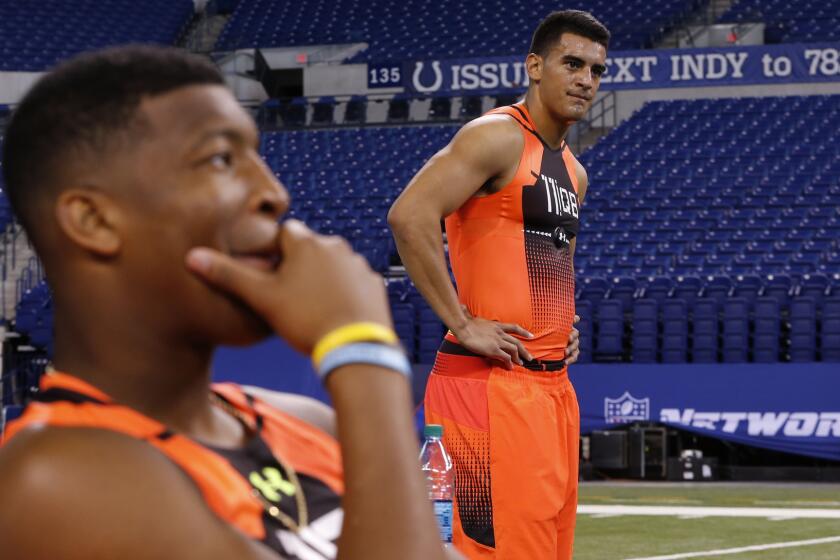 Oregon quarterback Marcus Mariota, right, stands next to Florida State quarterback Jameis Winston before taking part in a drill at the NFL Scouting Combine in Indianapolis on Feb. 21.