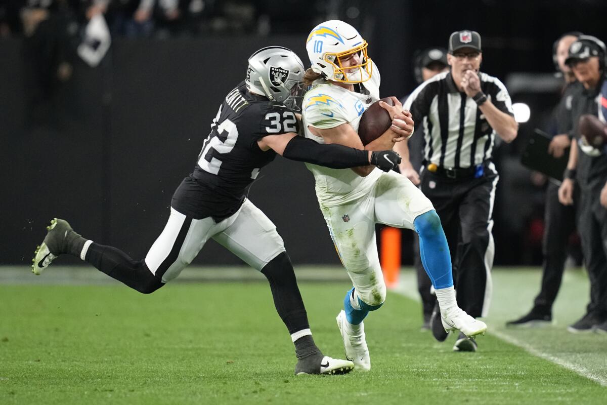 Chargers quarterback Justin Herbert carries the ball against the Las Vegas Raiders in January.