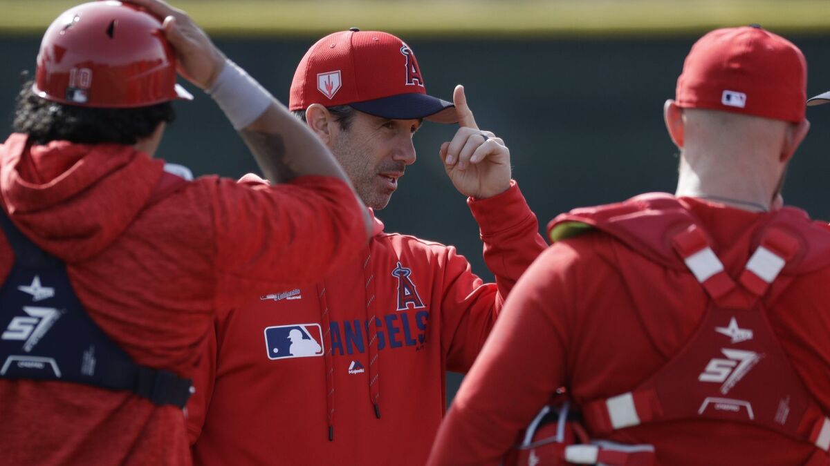 Angels manager Brad Ausmus talks with catchers during Friday practice at the spring-training facility in Tempe, Ariz.