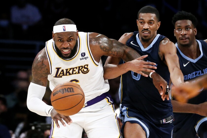 Lakers forward LeBron James, left, and Memphis Grizzlies guard De'Anthony Melton chase after a loose ball in the second half.