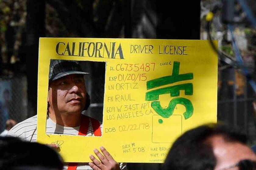 Raul Ortega holds a sign as he celebrates after Gov. Jerry Brown signed a measure allowing people in the country illegally to obtain driver's licenses.