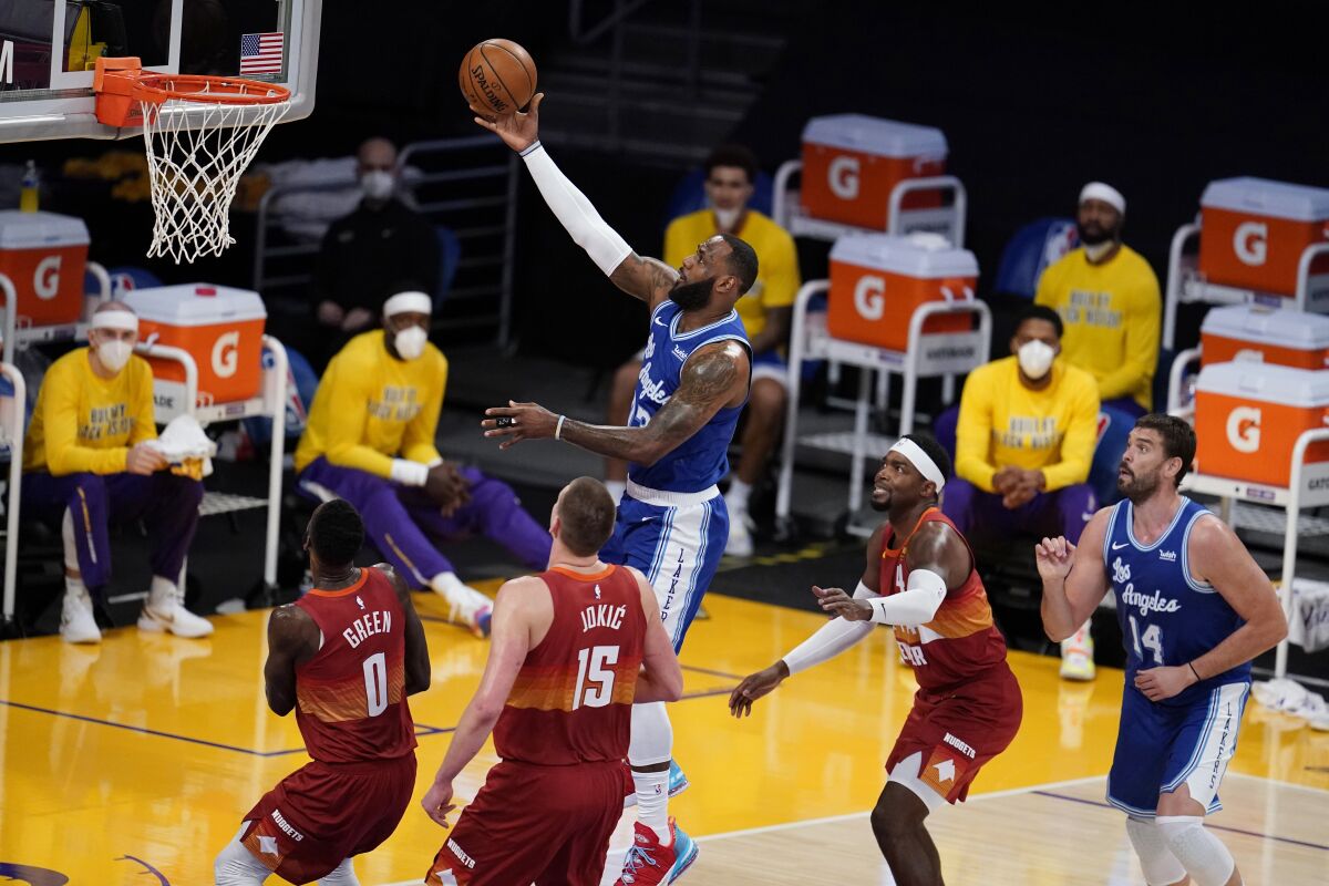 LeBron James, top, scores against the Denver Nuggets during a Lakers win on Thursday.