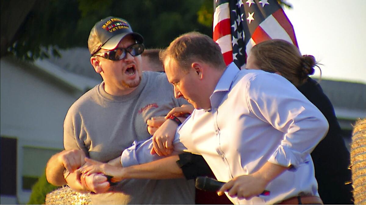 In this image taken from video provided by WHEC-TV, David Jakubonis, left, is subdued as he brandishes a sharp object during an attack U.S. Rep. Lee Zeldin, right, as the Republican candidate for New York governor delivered a speech in Perinton, N.Y., Thursday, July 21, 2022. Jakubonis, 43, has been charged with attempted assault, arraigned and released, a Monroe County sheriff's spokesperson said. (WHEC-TV via AP)