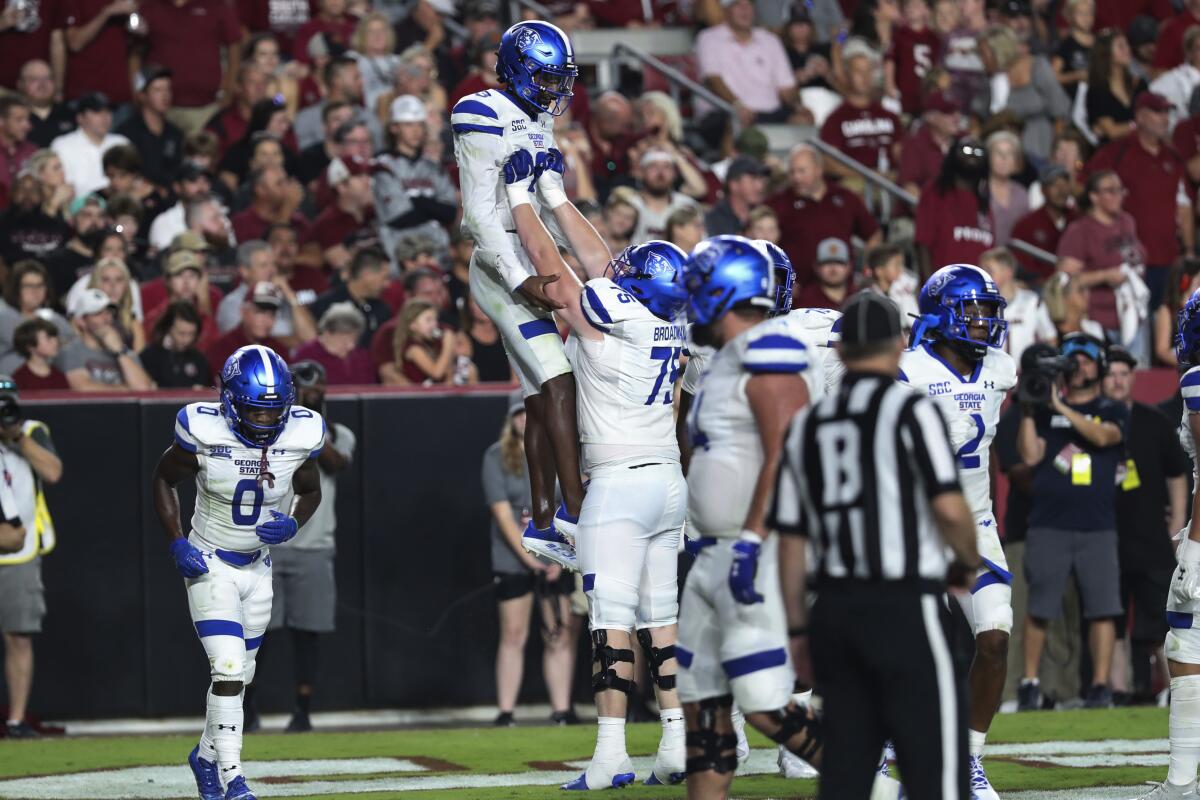 FILE - Georgia State offensive tackle Bryson Broadway (75) lifts quarterback Darren Grainger (3) up in the air to celebrate a touchdown during the team's NCAA college football game against South Carolina in Columbia, S.C., Saturday, Sept. 3, 2022. North Carolina (2-0) of the Atlantic Coast Conference will be in Atlanta on Saturday to face Georgia State (0-1), a school that only launched its football program a dozen years ago. (AP Photo/Artie Walker Jr., File)