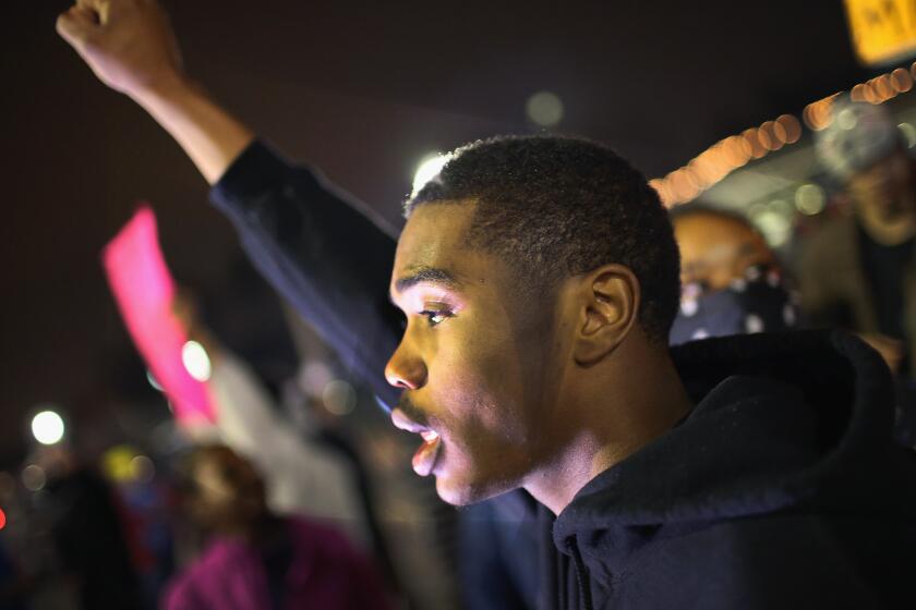 Demonstrators protest in front of the police station in Ferguson, Mo.