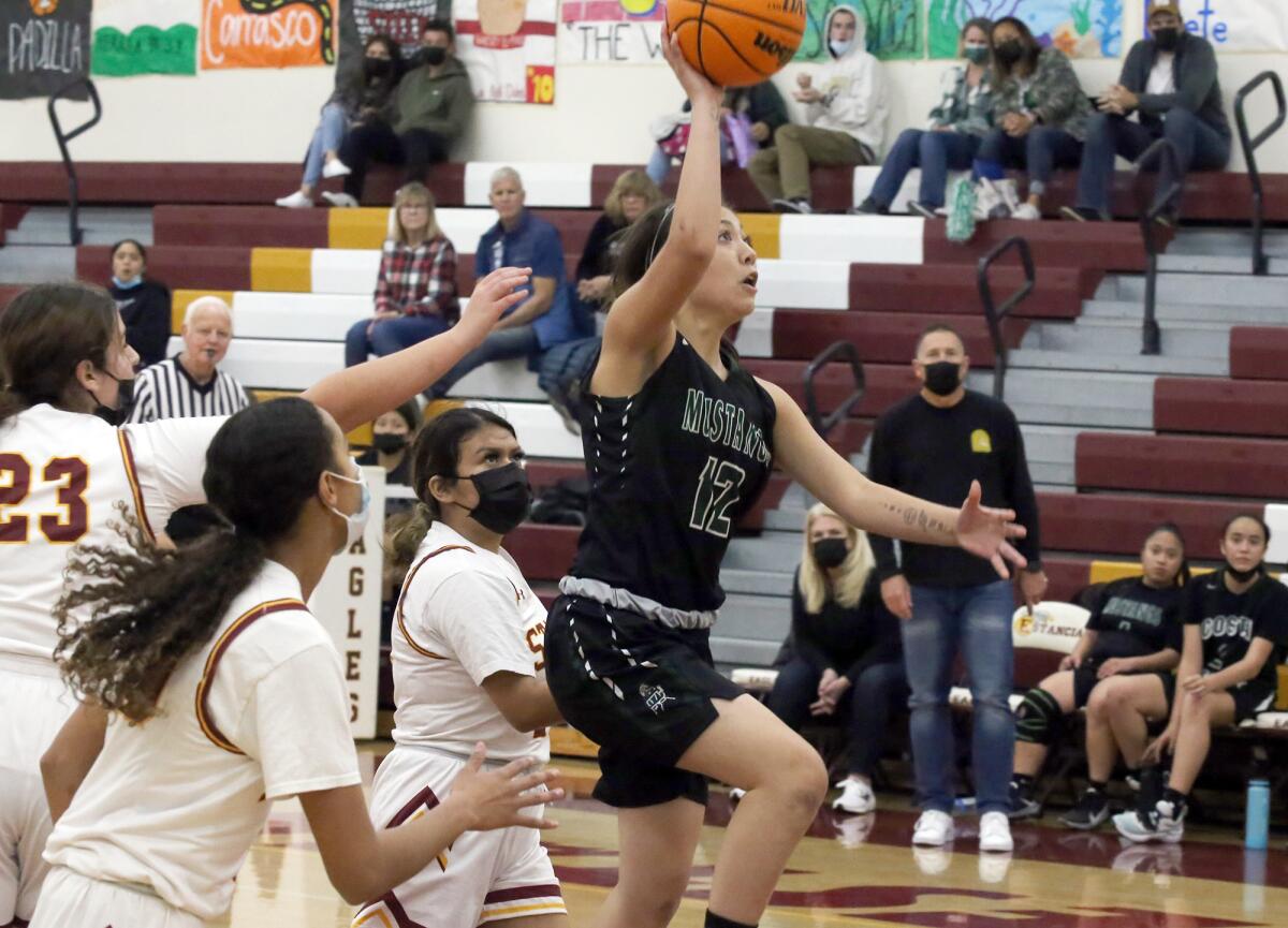Costa Mesa's Kim Molina (12) drives to the basket against Estancia in the Battle for the Bell on Tuesday.
