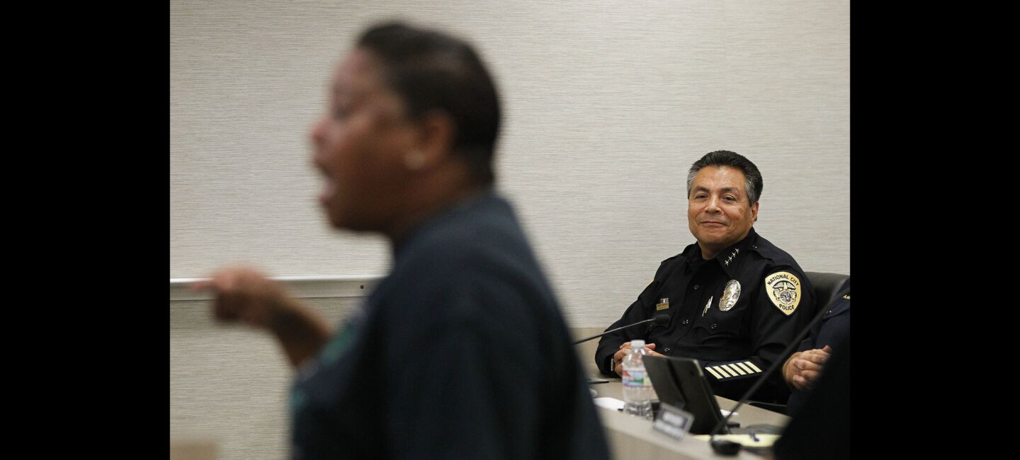 National City Police Chief Manuel Rodriguez watches as civil rights activist Tasha Williamson, foreground, yells toward city council members.