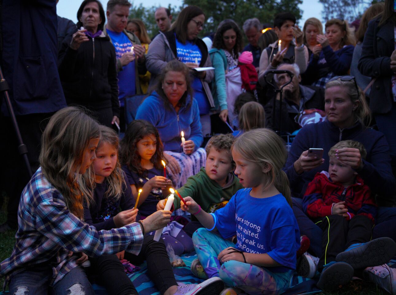 Children light candles during the vigil to remember the death of Poway resident Lori Gilbert-Kaye.