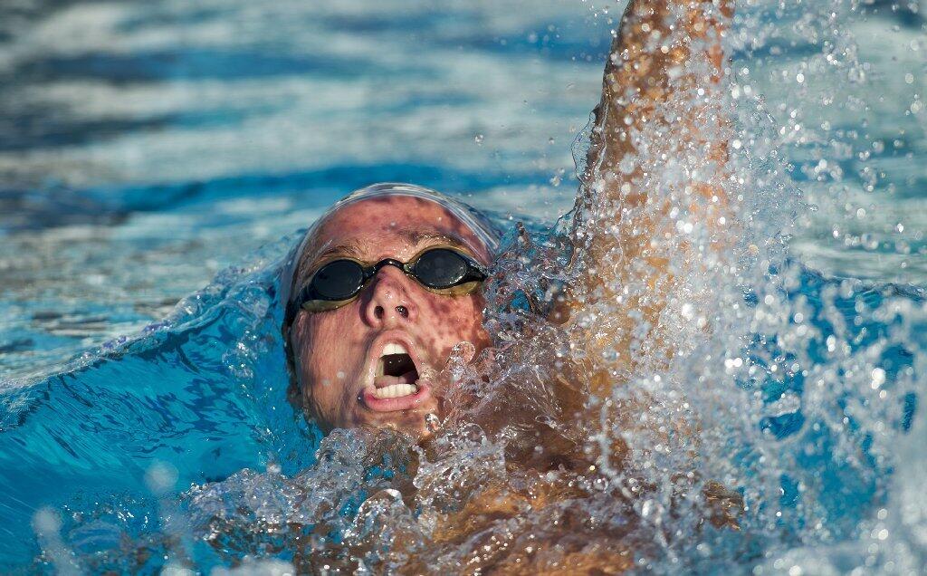 Corona del Mar's Tanner Pulice competes in the 100-yard backstroke during a Pacific Coast League meet against Irvine.