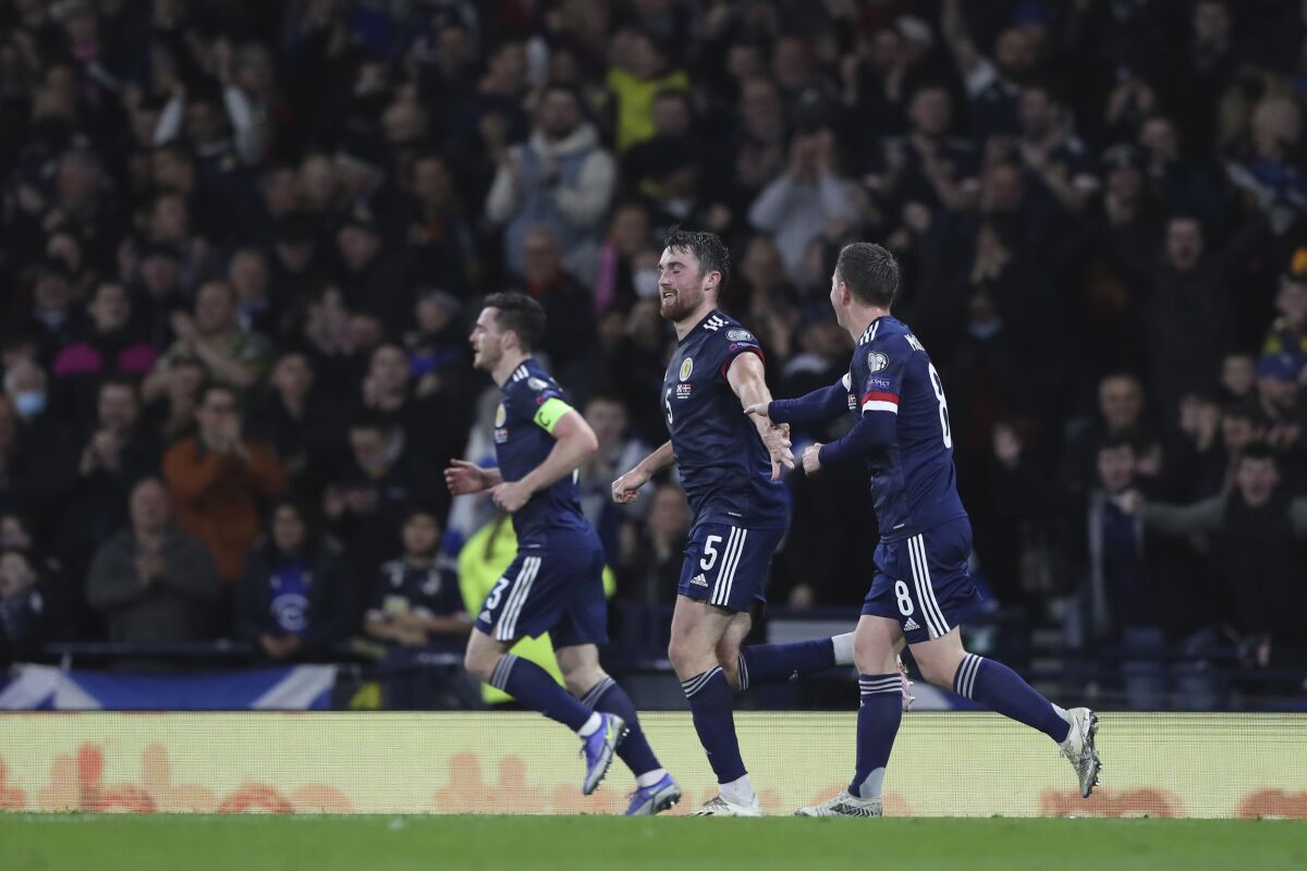 Scotland's John Souttar, center, celebrates after scoring his side's opening goal with his teammates during the World Cup 2022 group F qualifying soccer match between Scotland and Denmark at Hampden Park stadium in Glasgow, Scotland, Monday, Nov. 15, 2021. (AP Photo/Scott Heppell)