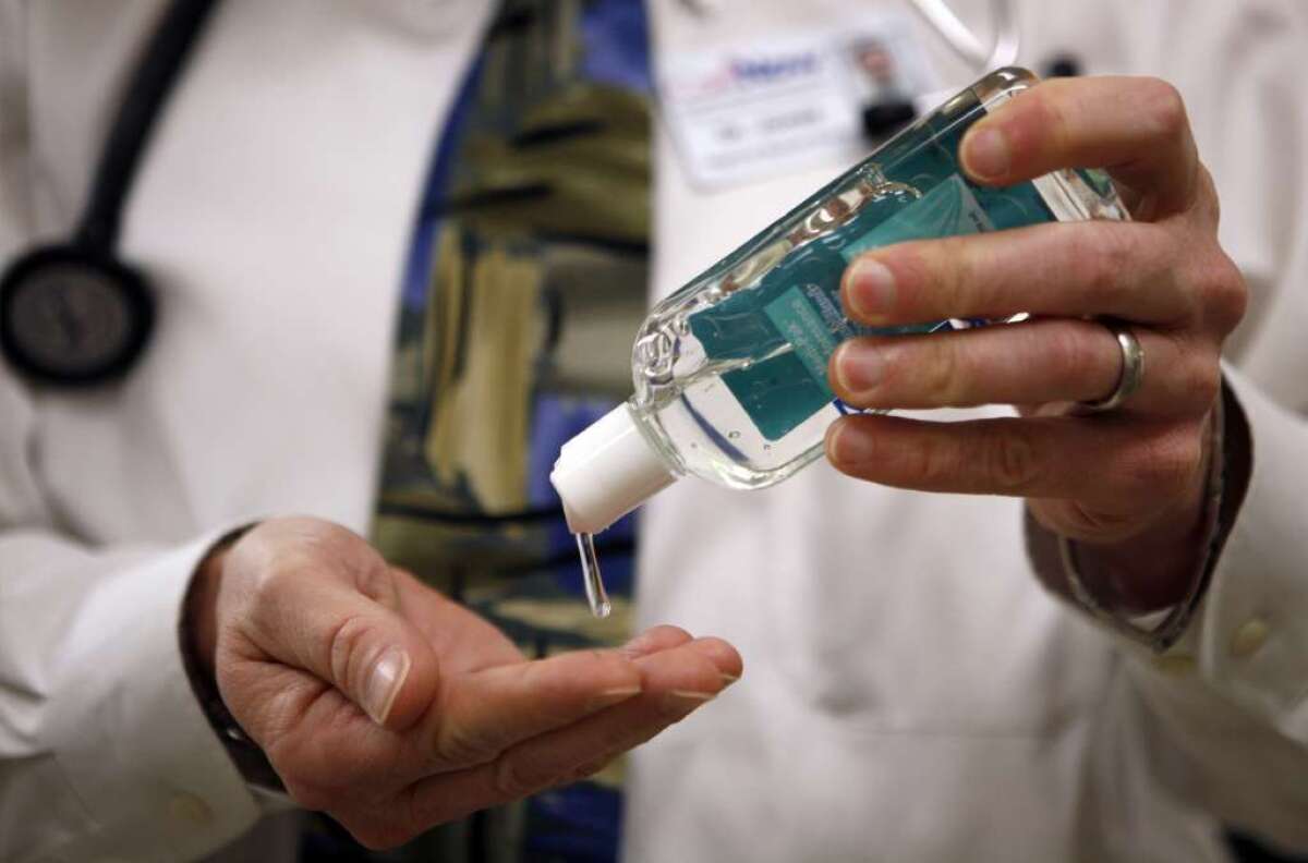 A doctor using hand sanitizer