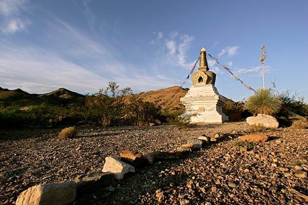 The early morning sun illuminates the stupa and prayer flags at Diamond Mountain University, a nonprofit Buddhist campus near Bowie, Ariz. Students and teachers are preparing for a silent retreat lasting three years, three months and three days.