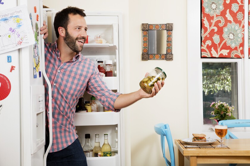 Dan Pashman of "The Sporkful" podcast holding a jar of pickles.