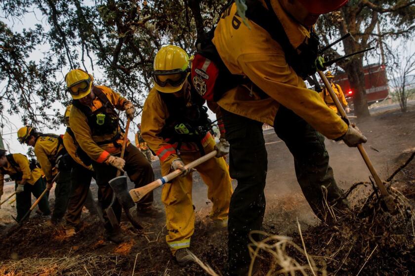 LAKEPORT, CALIF. -- TUESDAY, JULY 31, 2018: Portland firefighters do mop up work after putting out a spot fire on Highland Springs Road, in Lakeport, Calif., on July 31, 2018. (Marcus Yam / Los Angeles Times)