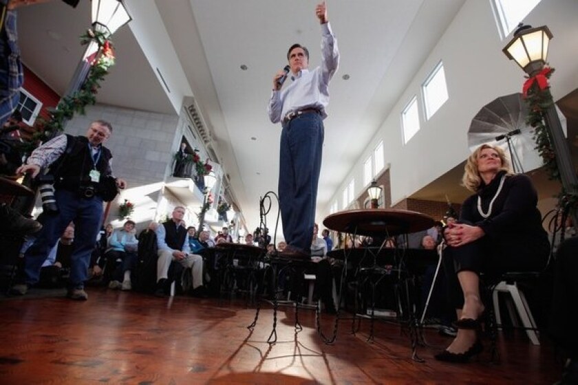 Mitt Romney stands in a chair while addressing voters in Mason City, Iowa.