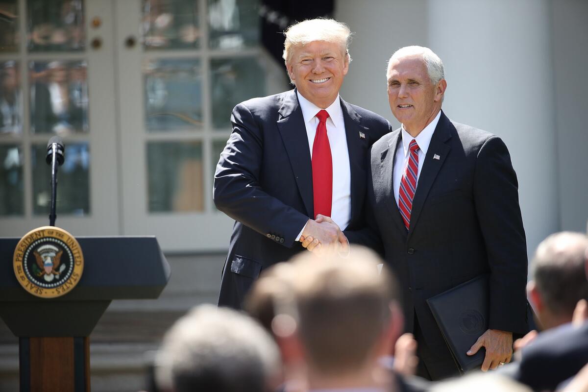 President Trump, left, greets Vice President Mike Pence before an announcement in the White House Rose Garden in June. Pence on Sunday vehemently denied any plan to seek the Republican presidential nomination in 2020.