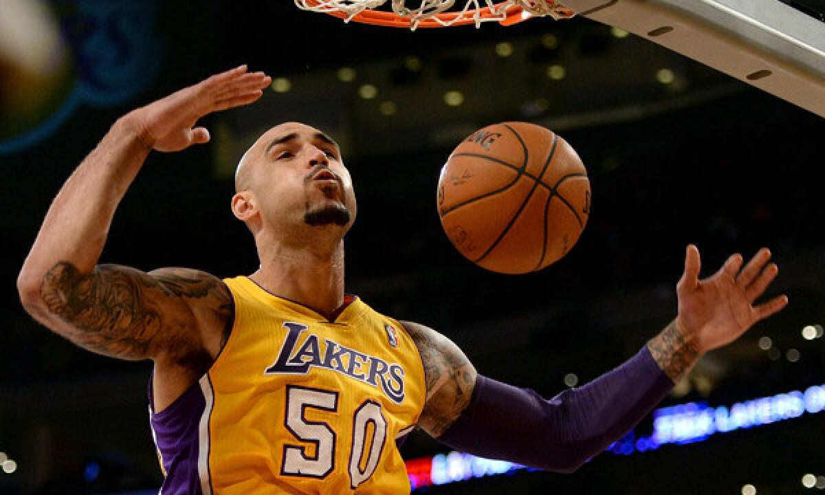 Lakers center Robert Sacre dunks during a win over the New York Knicks on Tuesday. Sacre is staying positive about his future and whether it involves the Lakers after this season.