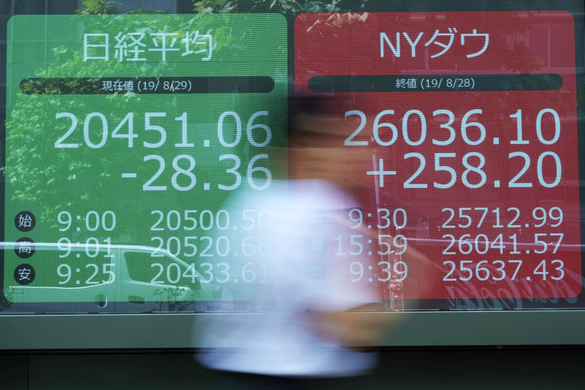 A man walks past an electronic stock board showing Japan's Nikkei 225 index at a securities firm in Tokyo Thursday, Aug. 29, 2019. Asian stocks declined Thursday following Wall Street's rebound amid uncertainty about U.S.-Chinese trade tension. (AP Photo/Eugene Hoshiko)