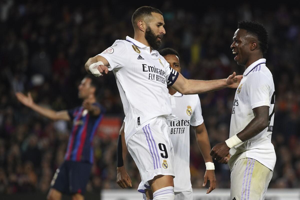 Vinicius Junior (derecha) y Karim Benzema celebran luego que Vinicius anotó el primer gol del Real Madrid