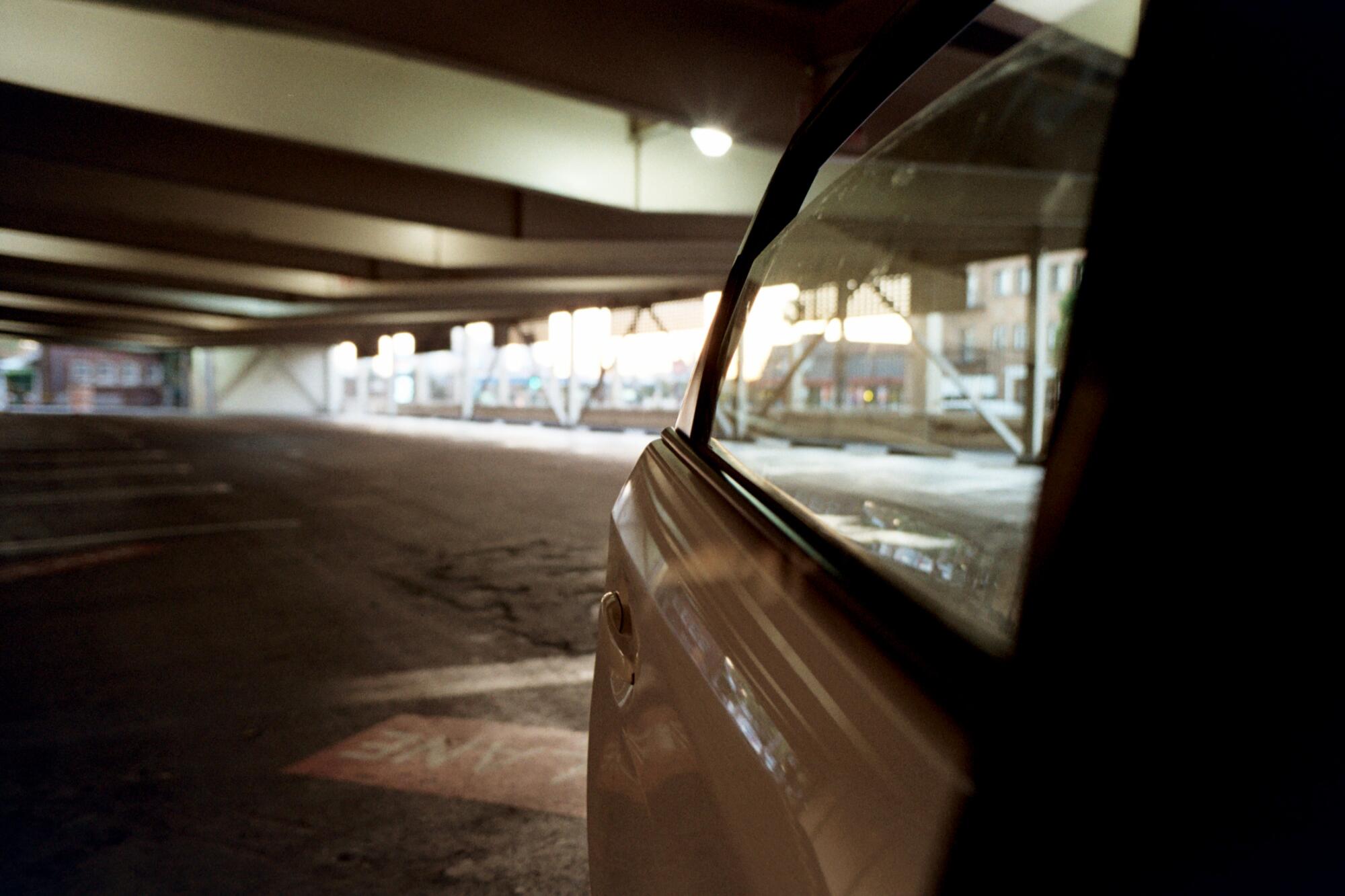 A car door opens into an otherwise-empty parking garage.