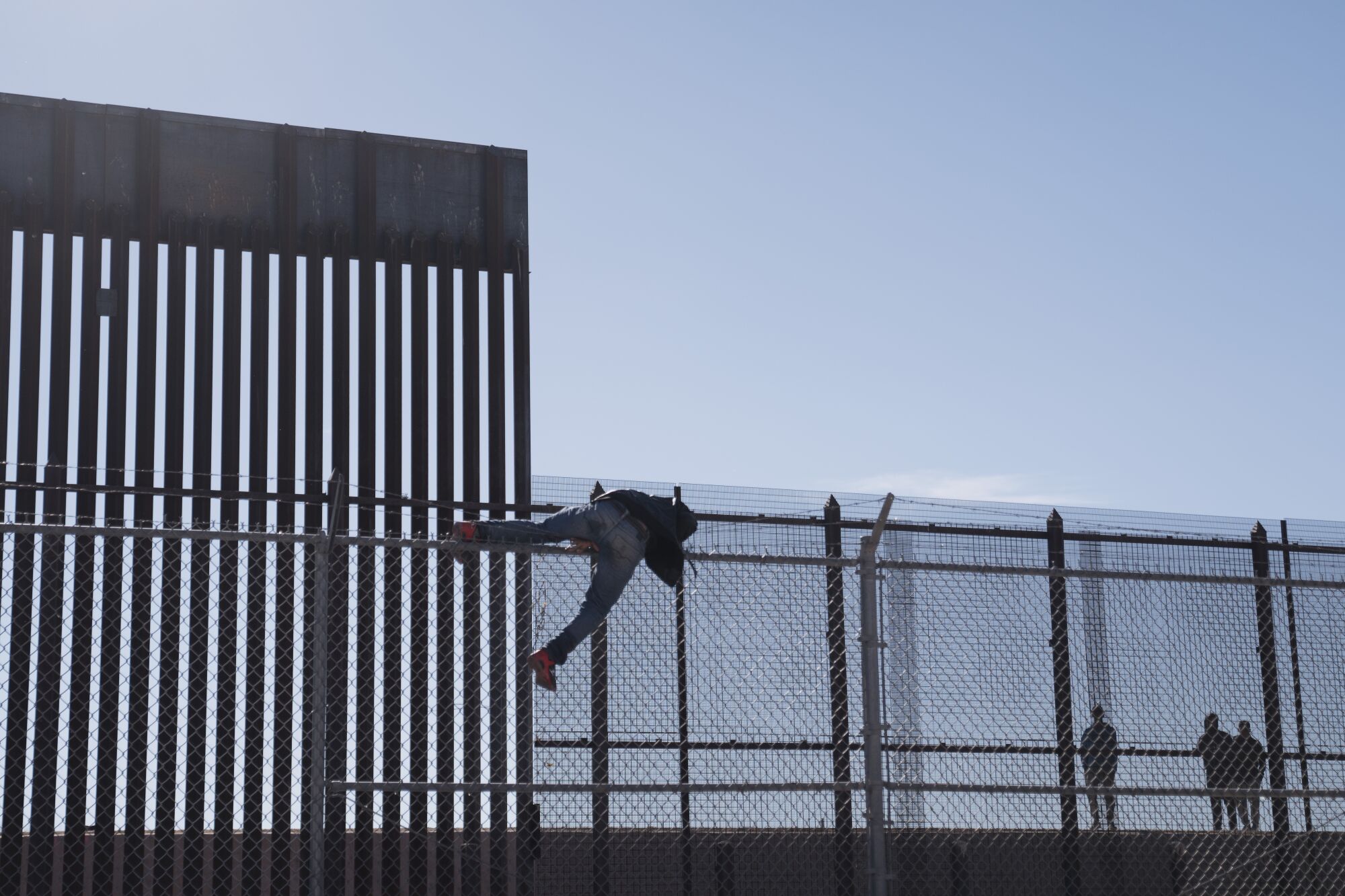 A person climbing over a fence 