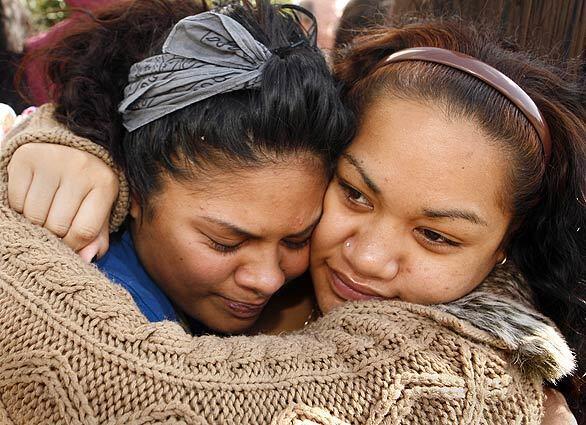 Susie Latweeka, left, is comforted by cousin Fiaora Tuitasi near the location in Long Beach where Latweeka's mother, Vanessa Malaepule, was found shot to death along with four others. The five were found in a brush-shrouded area next to the Santa Fe Avenue offramp on the 405 Freeway in Long Beach. Authorities described the site as a homeless encampment. Relatives say Malaepule wasn't homeless, just visiting a friend.