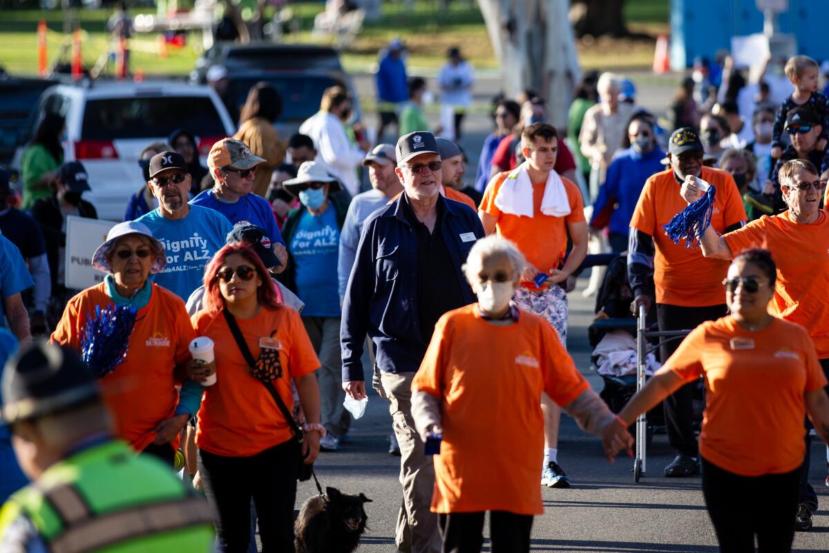 a group of people walk during a fundraiser event outdoors