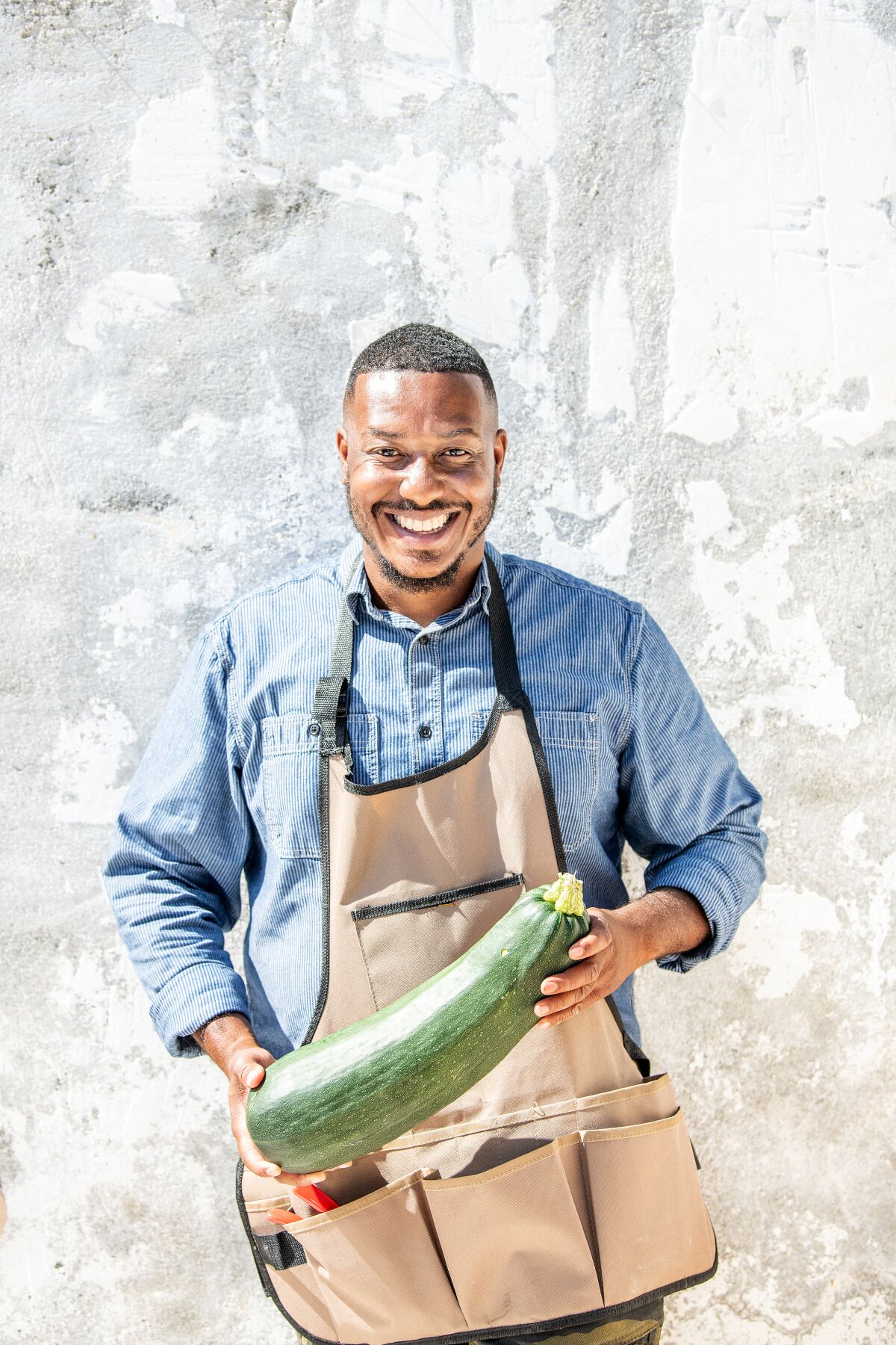 Ken Sparks holds a zucchini. 