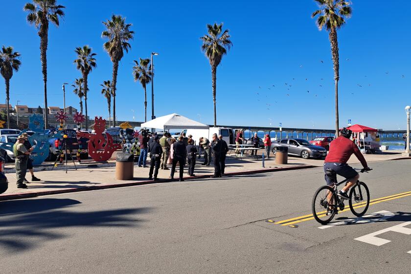 Park rangers, accompanied by San Diego police officers, conduct vendor enforcement Feb. 1 in Ocean Beach.