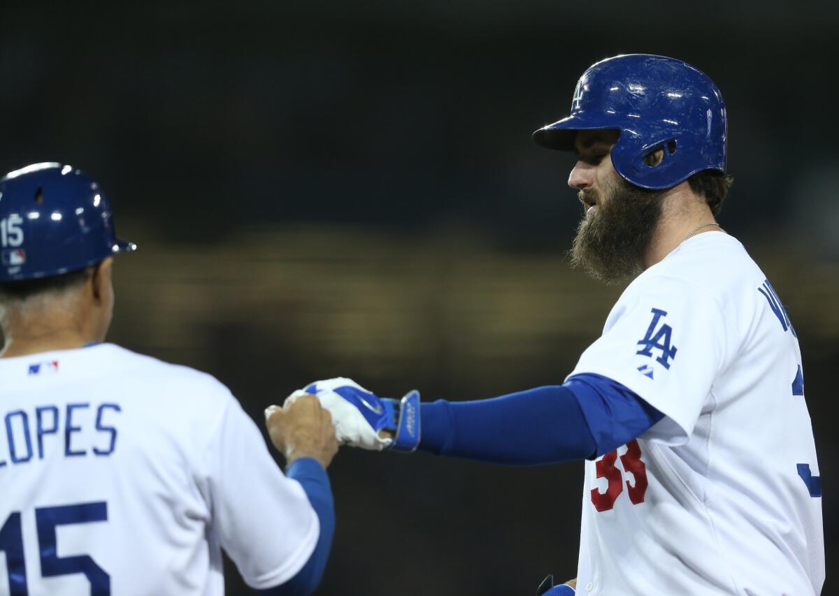 Dodgers outfielder Scott Van Slyke is congratulated by first base coach Davey Lopes after delivering a run-scoring single against the Colorado Rockies last season.