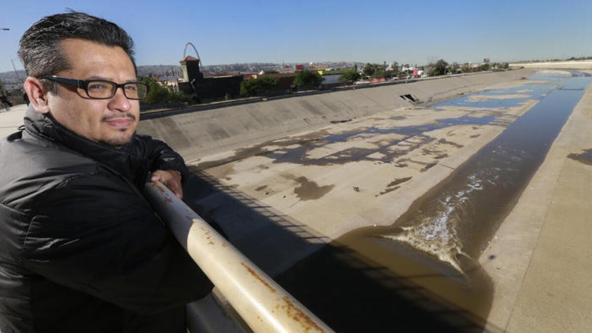 El arquitecto René Peralta, sobre el Río Tijuana. Él propone una granja solar y un sistema de limpieza de algas verdes para el canalizado río.