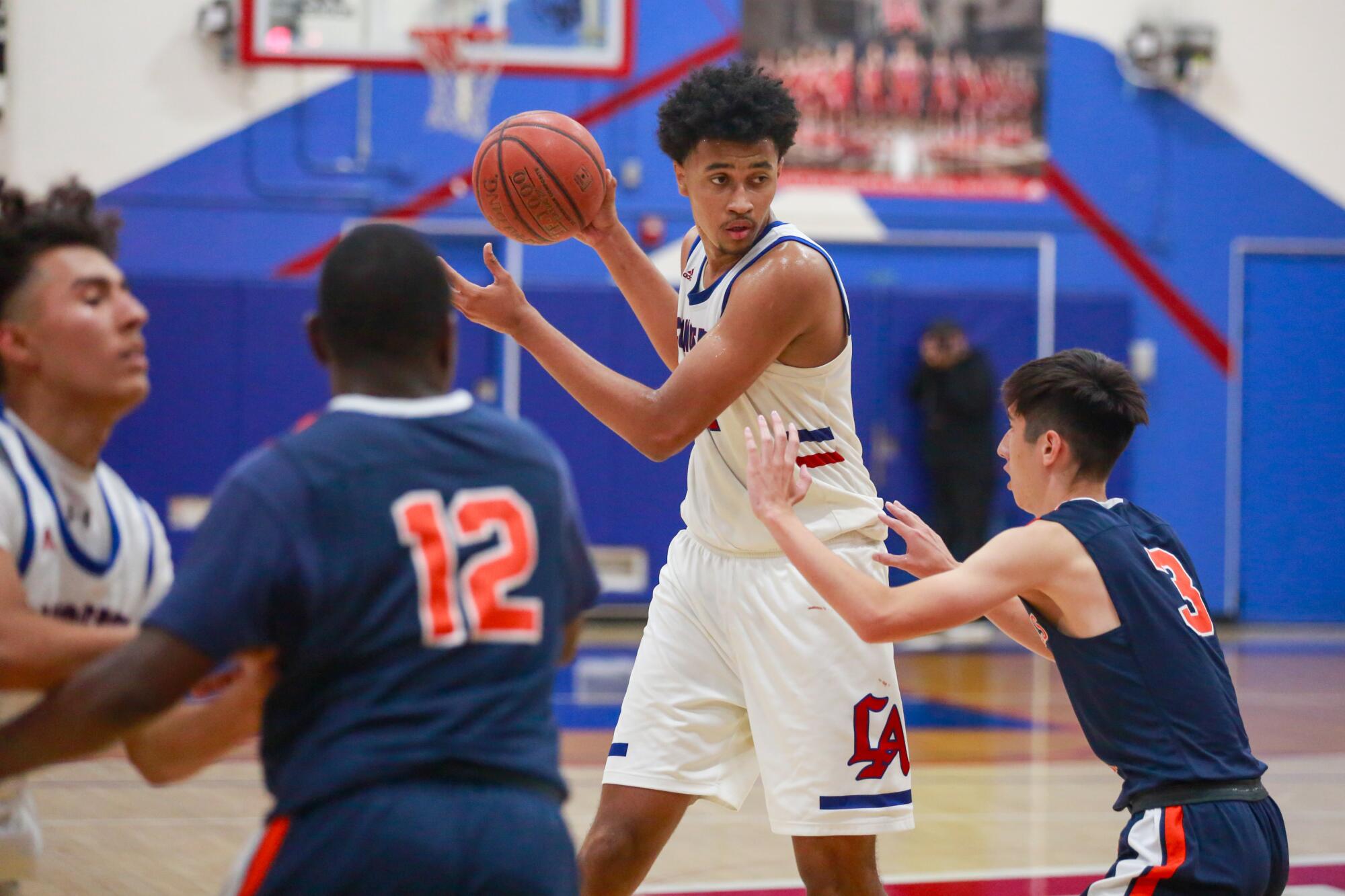 Los Altos sophomore Jazz Gardner towers over members of the opposing team on the basketball court.