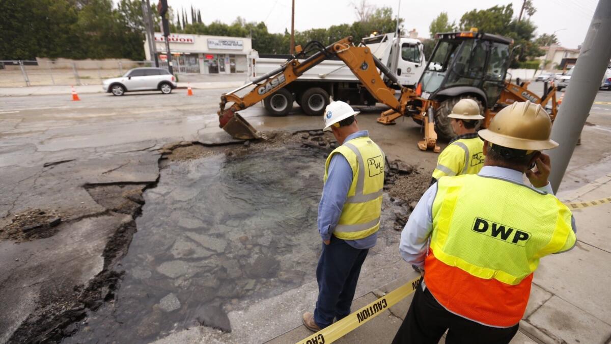 Department of Water and Power crews carve into Tampa Avenue in Tarzana after a water main break in 2017. The DWP could pay $38 million annually to rip open public streets under a proposal heading to the City Council.