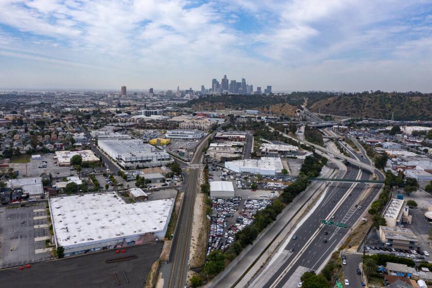 Lincoln Heights, California - April 26: Drone image of a warehouse, left, at 141 West Avenue 34, where a developer wants to build a five-story apartment complex Tuesday, April 26, 2022 in Lincoln Heights, California. Residents who live near the site protested the plan, saying the site was full of toxic waste and that they'd be exposed. (Brian van der Brug / Los Angeles Times)