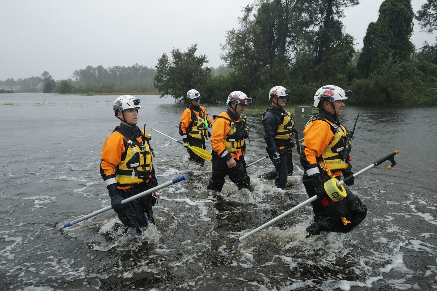 Members of the FEMA Urban Search and Rescue Task Force 4 from Oakland search a flooded neighborhood for evacuees in Fairfield Harbour, N.C.